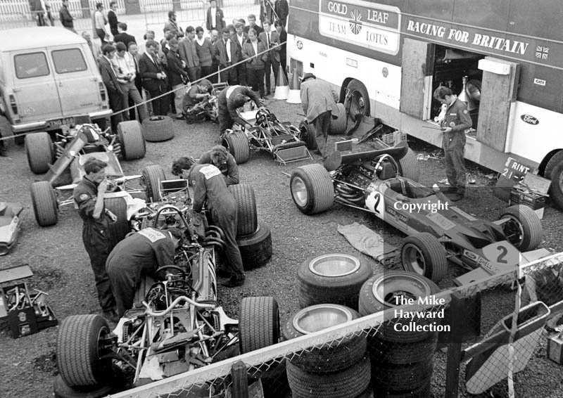 Gold Leaf Team Lotus mechanics working on the 49B's of Graham Hill and Jochen Rindt in the paddock, Silverstone, British Grand Prix 1969.
