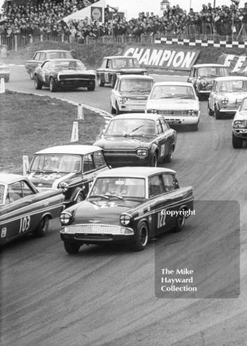 First lap at Paddock Bend with Chris Craft, Broadspeed Ford Anglia leading John Rhodes, Cooper Car Company Mini Cooper S, John Fitzpatrick, Broadspeed Ford Anglia, Brian Robinson, Lotus Cortina, Race of Champions, Brands Hatch, 1968
