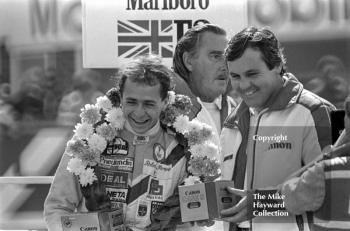 Roberto Moreno and Alan Jones on the podium with commentator Peter Scott-Russell, Marlboro British Formula 3 championship held at the 1981 Grand Prix, Silverstone.
