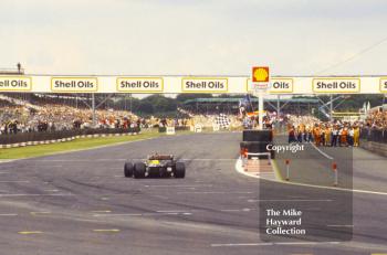 Nigel Mansell, Williams F11B,  takes the chequered flag, Silverstone, 1987 British Grand Prix.
